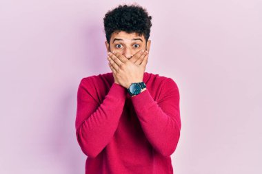 Sıradan pembe kazak giyen sakallı genç bir Arap yanlışlıkla elleriyle ağzını kapatmış. gizli kavram. 