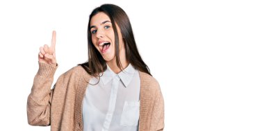 Gündelik beyaz gömlek ve ceket giyen genç esmer kız başarılı bir fikirle işaret ediyor. Heyecanlı ve mutlu. Bir numara.. 