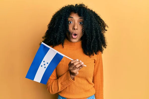 Африканская Американка Афроволосами Держащая Флаг Гондураса Испуганная Изумленная Открытым Ртом — стоковое фото