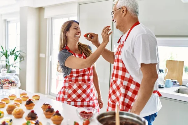 Casal Hispânico Meia Idade Sorrindo Feliz Dando Morango Outro Cozinha — Fotografia de Stock