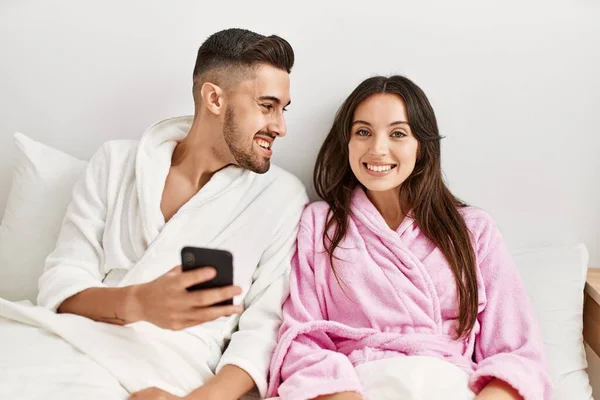 Jong Hispanic Paar Met Behulp Van Smartphone Liggend Bed Thuis — Stockfoto