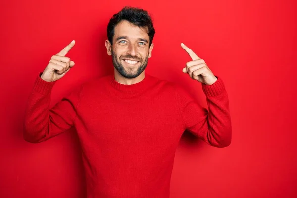 Snygg Man Med Skägg Klädd Avslappnad Röd Tröja Leende Pekar — Stockfoto