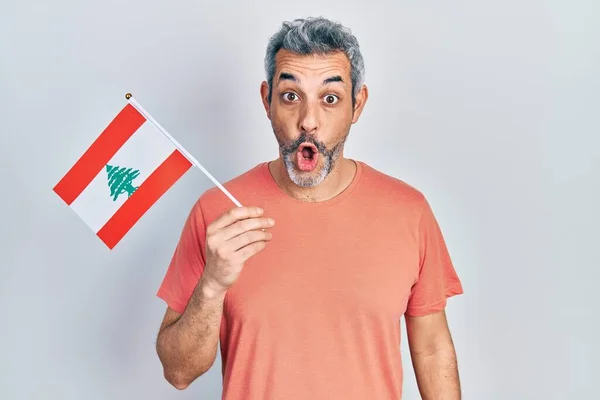 Przystojny Mężczyzna Średnim Wieku Siwymi Włosami Trzymający Flagę Libanu Przerażony — Zdjęcie stockowe