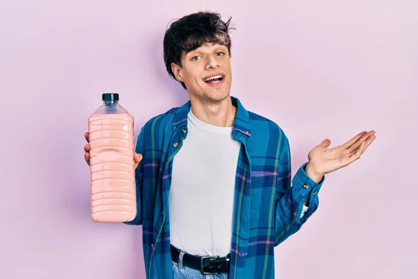 Przystojny Hipster Młody Człowiek Trzymając Butelkę Detergentu Świętując Osiągnięcie Szczęśliwym — Zdjęcie stockowe