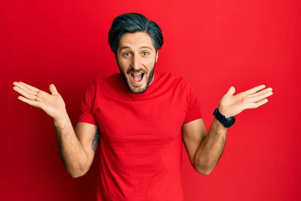 Joven Hombre Hispano Vistiendo Casual Camiseta Roja Celebrando Loco Sorprendido —  Fotos de Stock