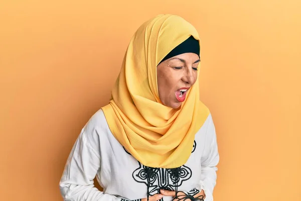 胃の上に手で伝統的なイスラム教のヒジャーブスカーフを身に着けている中世のヒスパニック女性は吐き気 痛みを伴う病気が体調を崩します キャッシュ コンセプト — ストック写真
