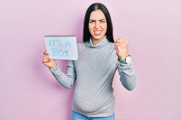 Beautiful woman with blue eyes expecting a baby holding its a boy banner annoyed and frustrated shouting with anger, yelling crazy with anger and hand raised 