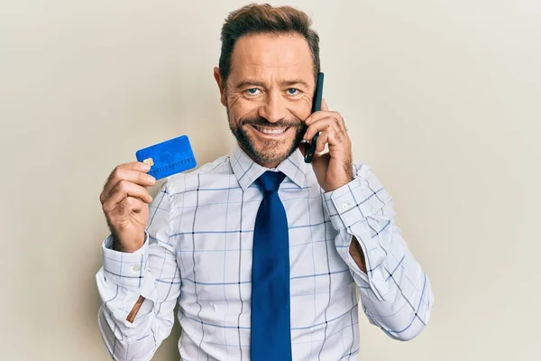 Бізнесмен Середнього Віку Розмовляє Смартфону Тримаючи Кредитну Картку Посміхаючись Щасливою — стокове фото