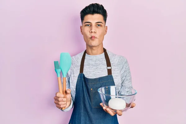 Jovem Hispânico Segurando Massa Pão Ferramentas Cozinha Fazendo Cara Peixe — Fotografia de Stock