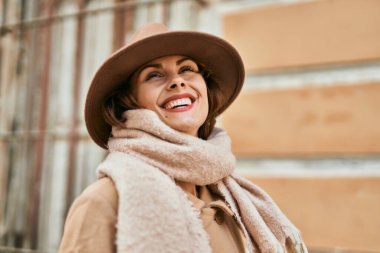 Şık giyinen genç İspanyol kadın şehirde dikiliyor..