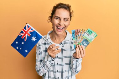 Genç esmer kadın elinde Avustralya bayrağı ve dolarlarla kahkahalarla gülüyor.. 