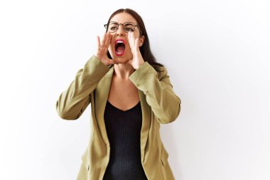 Genç esmer kadın izole edilmiş arka planda duruyor ve elleri ağızda bağırıyor. 