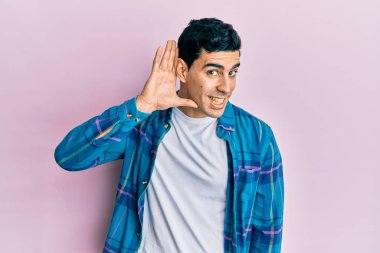 Sıradan kıyafetler giyen yakışıklı İspanyol bir adam. Kulaktan kulağa gülümsüyor. Dedikoduları ve dedikoduları dinliyor. Sağırlık kavramı. 