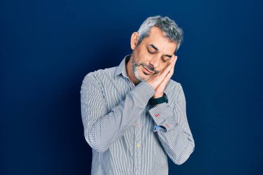 Yakışıklı, orta yaşlı, gri saçlı, iş gömleği giyen, uyuyan, yorgun, hayal kuran, elleriyle poz veren, gözleri kapalı bir adam.. 