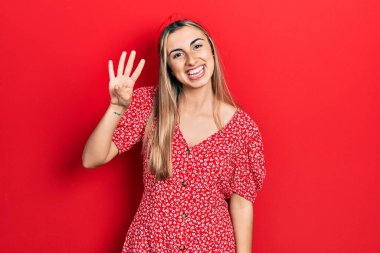 Güzel İspanyol kadın yaz elbisesi giyer ve parmaklarıyla dört numarayı gösterir. Kendinden emin ve mutlu gülümserken.. 