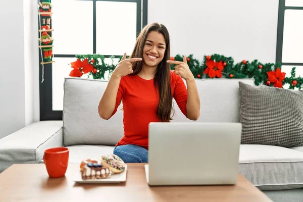 Jovem Morena Usando Laptop Sentado Sofá Natal Sorrindo Alegre Mostrando — Fotografia de Stock