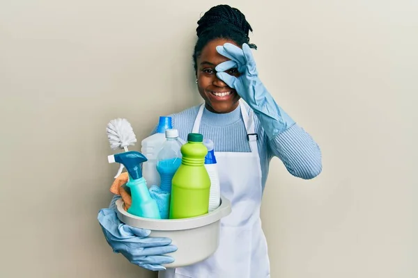 Mujer Afroamericana Con Pelo Trenzado Usando Delantal Sosteniendo Productos Limpieza —  Fotos de Stock