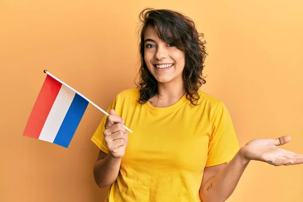 Jovem Hispânica Segurando Bandeira Holandesa Celebrando Realização Com Sorriso Feliz — Fotografia de Stock