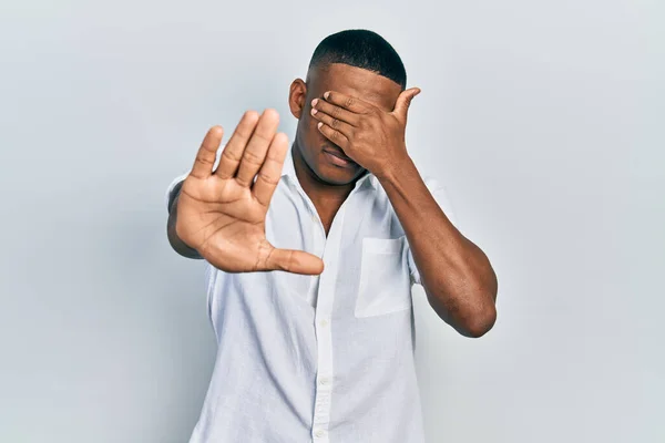 Jovem Negro Vestindo Camisa Branca Casual Cobrindo Olhos Com Mãos — Fotografia de Stock