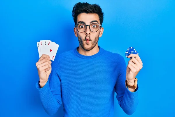 Jovem Hispânico Jogando Pôquer Segurando Fichas Cassino Cartões Fazendo Cara — Fotografia de Stock