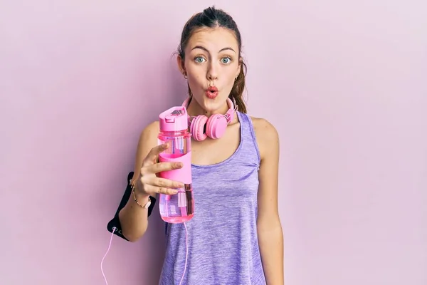 Junge Brünette Frau Sportbekleidung Trinkt Flasche Wasser Verängstigt Und Erstaunt — Stockfoto