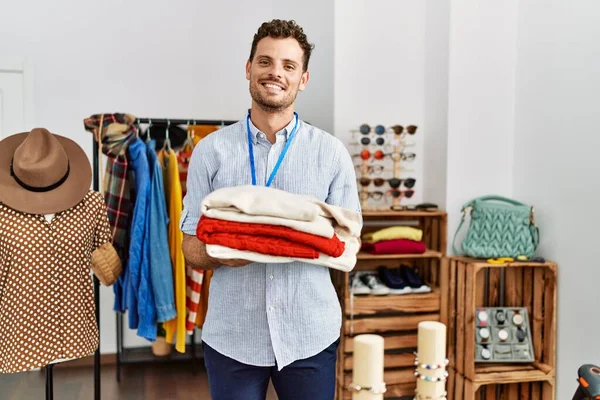 Jovem Lojista Hispânico Homem Sorrindo Feliz Segurando Pilha Suéter Loja — Fotografia de Stock