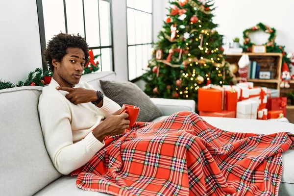 Jovem Afro Americano Sentado Sofá Bebendo Café Pela Árvore Natal — Fotografia de Stock