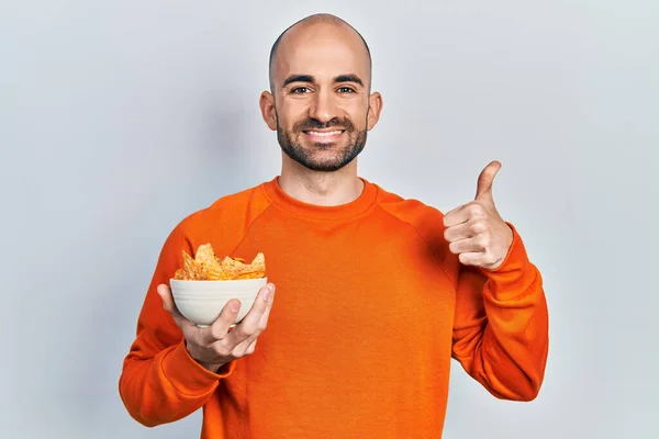 Young Bald Man Holding Nachos Potato Chips Smiling Happy Positive — Stock Photo, Image