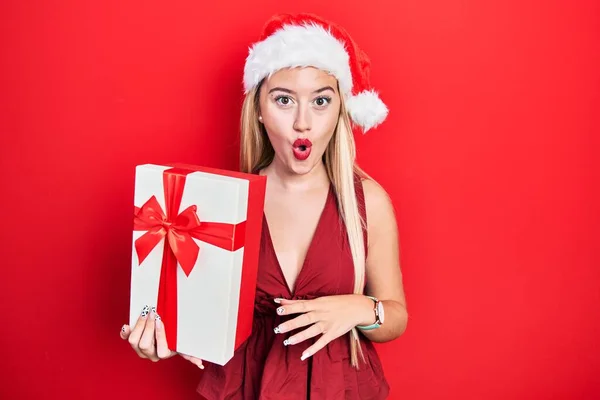 Jovem Loira Vestindo Chapéu Natal Segurando Presentes Assustados Surpresos Com — Fotografia de Stock