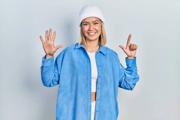 Schöne Blonde Frau Trägt Wollmütze Und Zeigt Mit Finger Nummer — Stockfoto