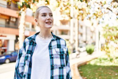 Modern beyaz saç stili ile genç ve güzel bir kadın dışarıda mutlu bir şekilde gülümsüyor.