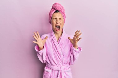 Duş başlığı ve bornoz giyen genç sarışın kadın başarıya deli ve deli gibi seviniyor. Kolları havada ve gözleri kapalı heyecanla bağırıyor. Kazanan konsept 