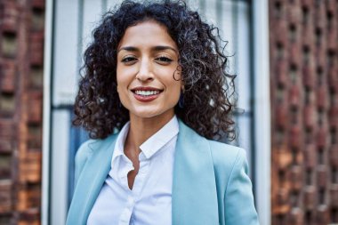 Profesyonel giyinen genç İspanyol iş kadını. Şehre güler yüzlü bakıyor.