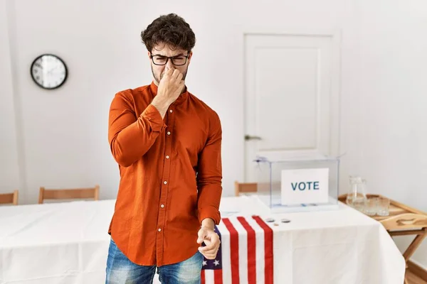 選挙室に立つヒスパニック系の男性は 鼻の上に指で息を保持し 臭いと嫌な 耐え難い匂いを嗅ぐ 臭いが悪い — ストック写真