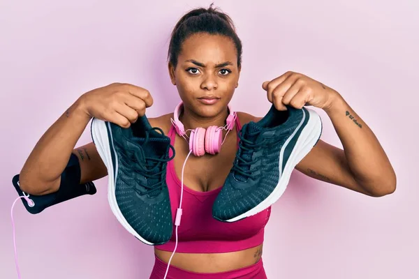 아프리카 미국인 여자가 헤드폰을 스포츠용 신발을 회의적 모습을 보이며 문제로 — 스톡 사진