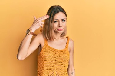 Sarışın, sıradan bir tişört giyen genç, beyaz bir kadın silah gibi elini ve parmaklarını havaya kaldırarak kendini vuruyor, intihar ediyor.. 