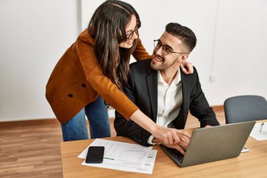 Ofiste çalışırken gülümseyen iki İspanyol iş adamı..