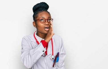 Genç Afro-Amerikan kadın doktor üniforması giyiyor ve steteskop ağızda gizli söylentiler yayıyor, kötü niyetli konuşmalar fısıldıyor. 