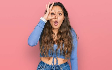 Günlük kıyafetler giyen genç İspanyol kız şaşırmış yüz ifadesiyle şok olmuş, parmaklarından bakan gözler. İnançsız ifade. 