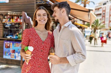 Genç İspanyol çift gülümsüyor, şehirde dondurma yiyorlar..