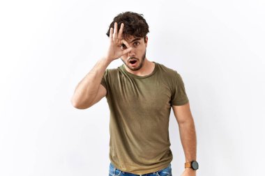 İzole edilmiş beyaz arka planda duran İspanyol bir adam şaşırmış yüz ifadesiyle şaşırmış, parmaklarından bakan bir jest yapıyor. İnançsız ifade. 