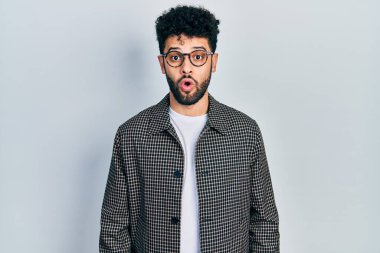 Sakallı, gözlüklü genç bir Arap. Şaşırmış ve korkmuş bir ifade, korku ve heyecanlı bir yüz.. 