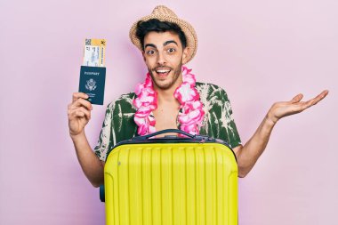 Yaz stili giyinen İspanyol genç bir adam ve elinde pasaport ve biniş kartı olan Hawai zambağı olan mutlu bir gülümsemeyle zaferi kutlayan ve kazanan bir ifadeyle elini kaldıran bir adam. 