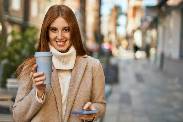 Νεαρή Κοκκινομάλλα Κοπέλα Που Χρησιμοποιεί Smartphone Πίνοντας Καφέ Στην Πόλη — Φωτογραφία Αρχείου