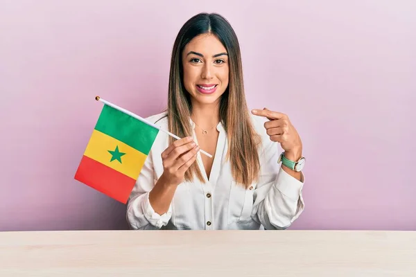 Jovem Hispânica Segurando Bandeira Senegal Sentado Mesa Sorrindo Feliz Apontando — Fotografia de Stock