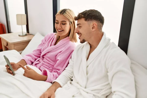 Jovem Casal Caucasiano Sorrindo Feliz Usando Smartphone Sentado Cama Casa — Fotografia de Stock