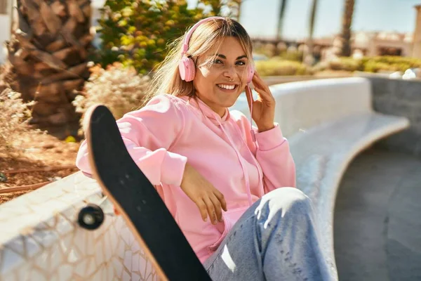 Joven Chica Rubia Patinadora Sonriendo Feliz Usando Auriculares Sentados Parque —  Fotos de Stock