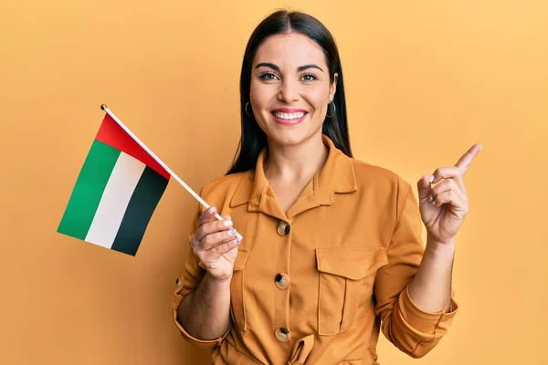 Fiatal Barna Gazdaság Egyesült Arab Emirates Zászló Mosolyogva Boldog Mutató — Stock Fotó