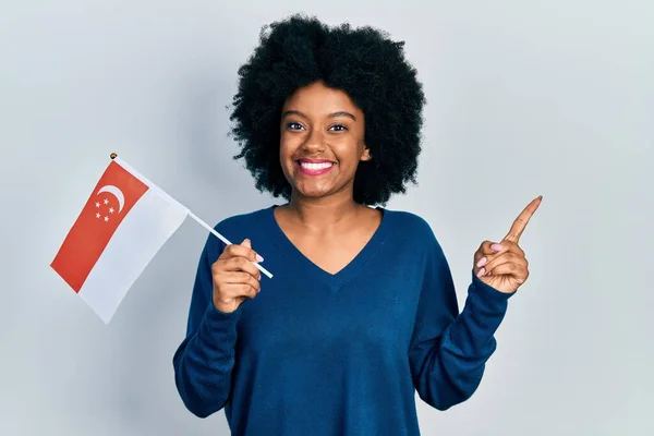 Молодая Африканская Американка Сингапорским Флагом Улыбается Показывая Рукой Пальцем Сторону — стоковое фото