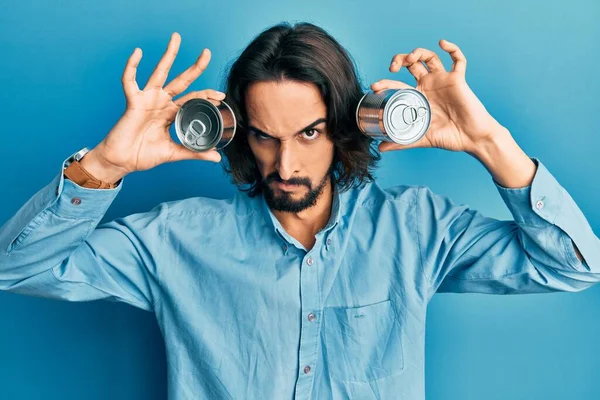 Young Hispanic Man Holding Canned Food Eyes Skeptic Nervous Frowning — Stock Photo, Image